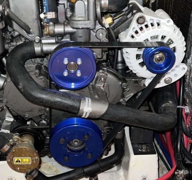 Close-up of a marine engine with alternator, pulleys, and drive belts